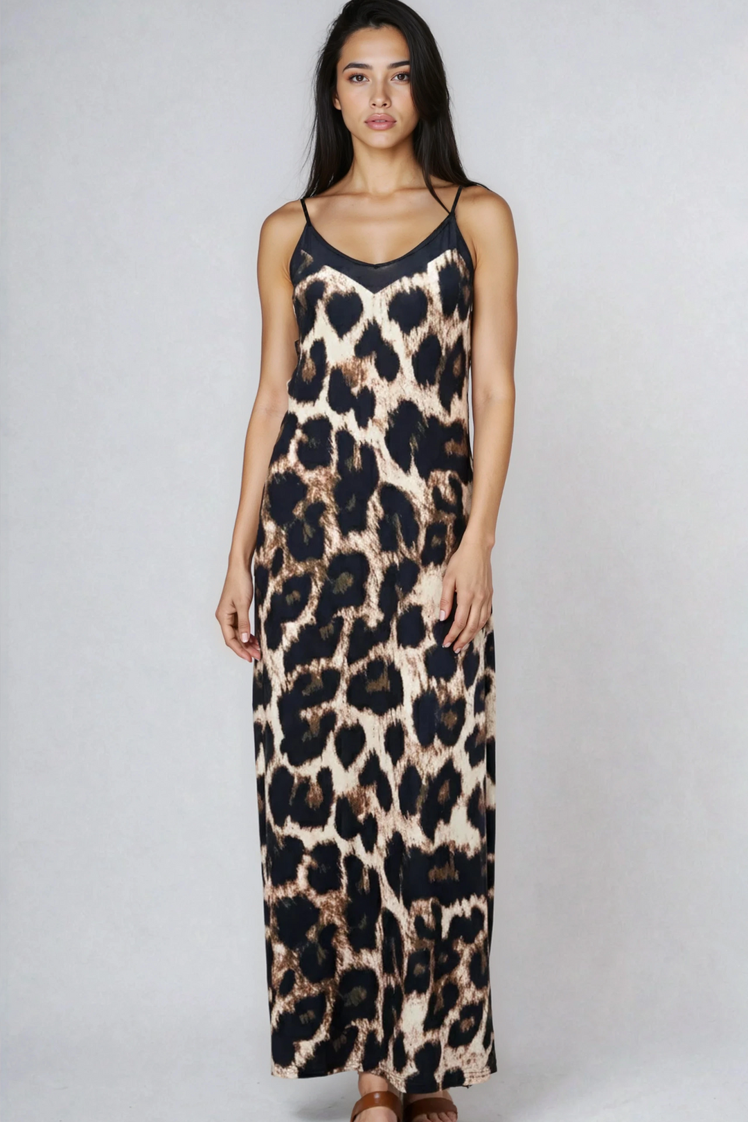 Woman wearing a leopard print dress on a plain background