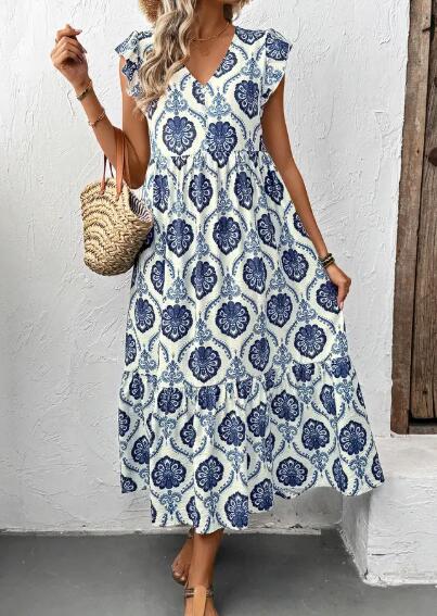 Woman wearing a blue and white patterned dress against a white wall.