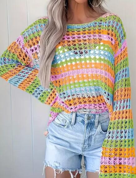 Person wearing a colorful crochet sweater and denim shorts against a white background
