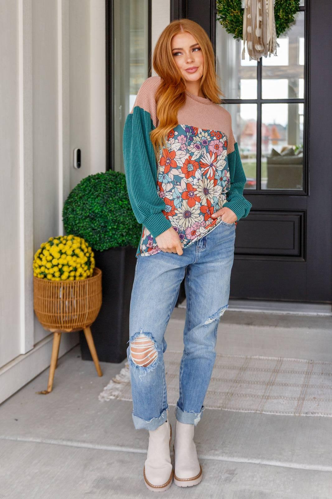 Model in floral color block top and ripped jeans