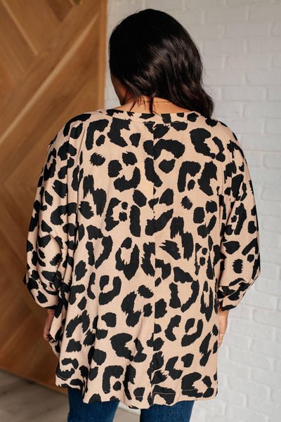 Back view of animal print batwing blouse on model.