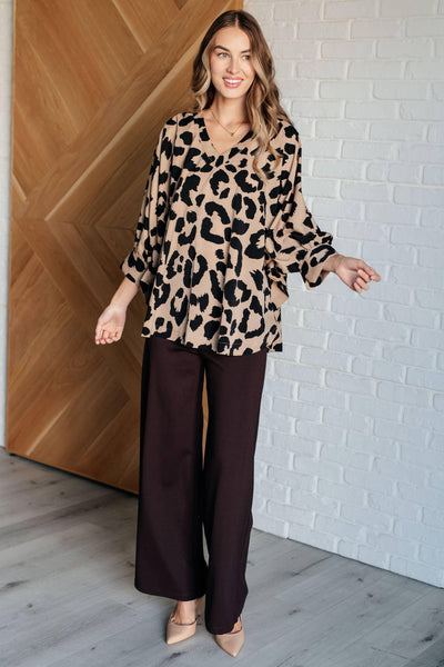 Animal print blouse with wide-leg pants on model.