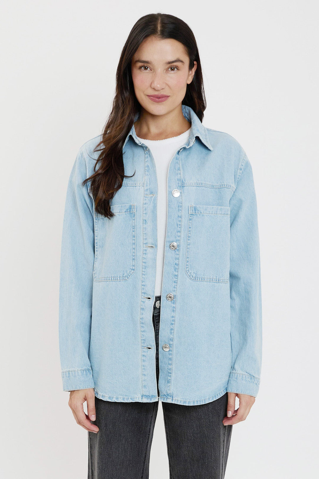 Woman wearing a light blue denim jacket on a white background