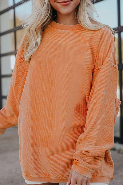 Orange ribbed corduroy sweatshirt in casual setting