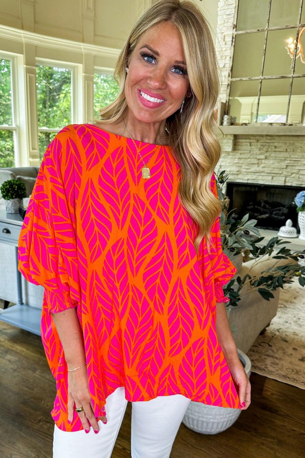 Model smiling in tropical leaf print blouse with puff sleeves