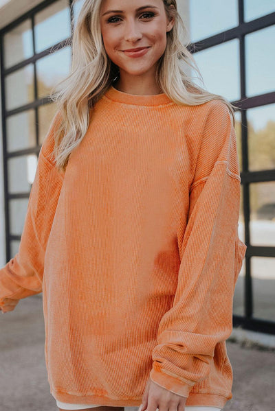 Orange ribbed corduroy sweatshirt on hanger front