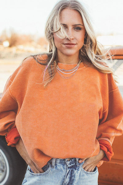 Orange ribbed sweatshirt styled with jeans