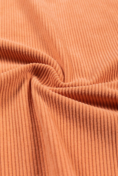 Stitching detail on orange ribbed sweatshirt