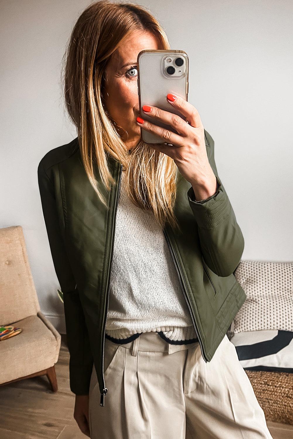 Model wearing sage green faux leather jacket with beige pants