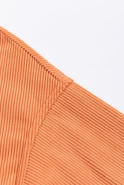 Orange ribbed sweatshirt on hanger isolated