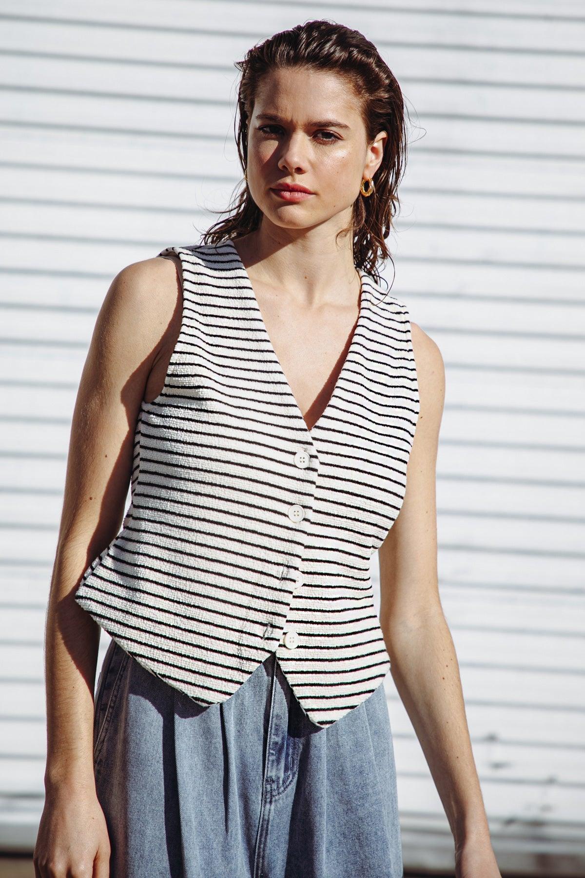 Front view of cream and black striped knit vest with buttons.