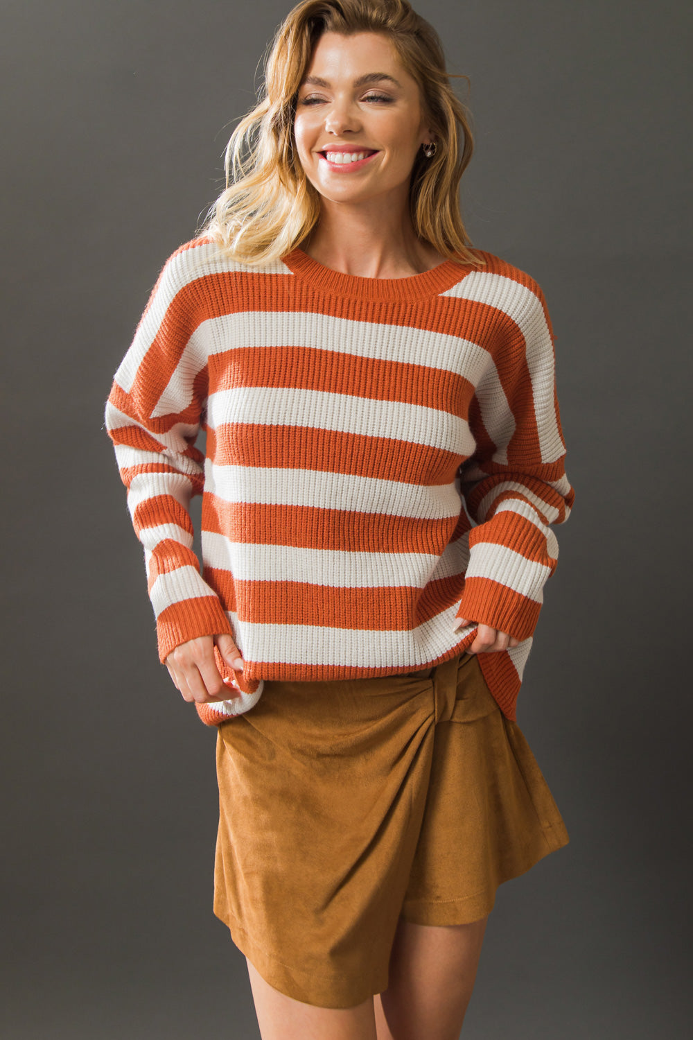 Smiling model in rust and ivory striped sweater top