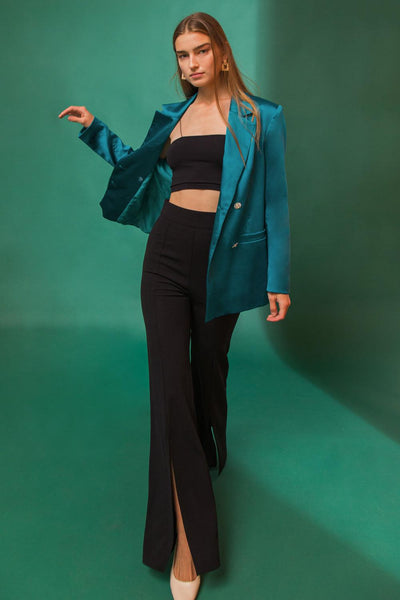 Teal blazer with black crop top and flared pants