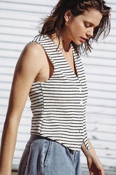 Side profile of cream and black striped knit vest.