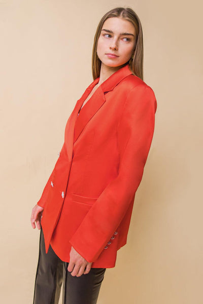 Orange blazer with black pants, side view